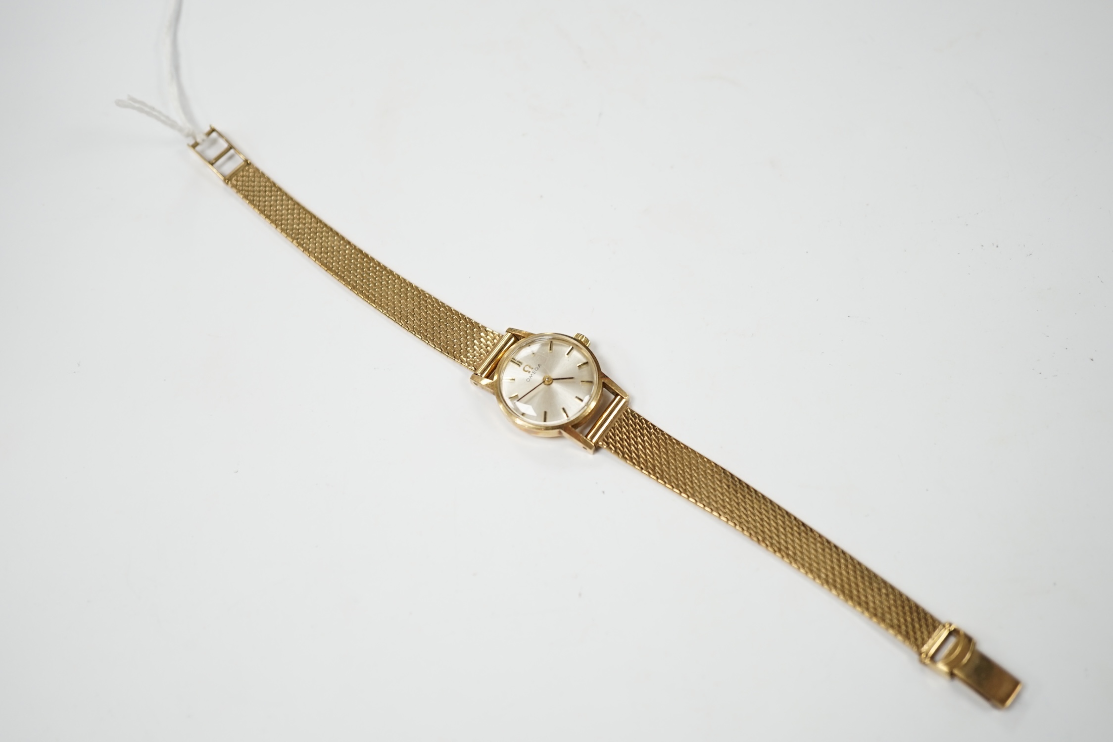 A lady's modern 9ct gold Omega manual wind wrist watch, on an associated 9ct gold bracelet, overall 18cm, gross weight 21.8 grams. Condition - fair